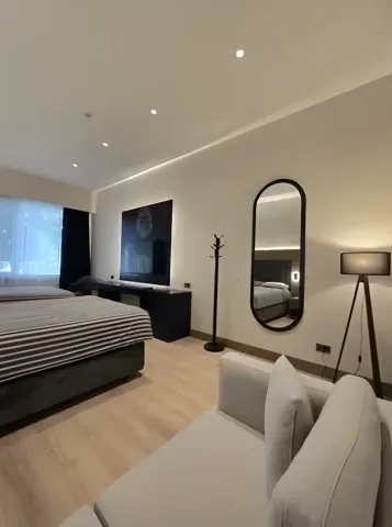 Oturma köşesi ve oval aynalı konaklama odası